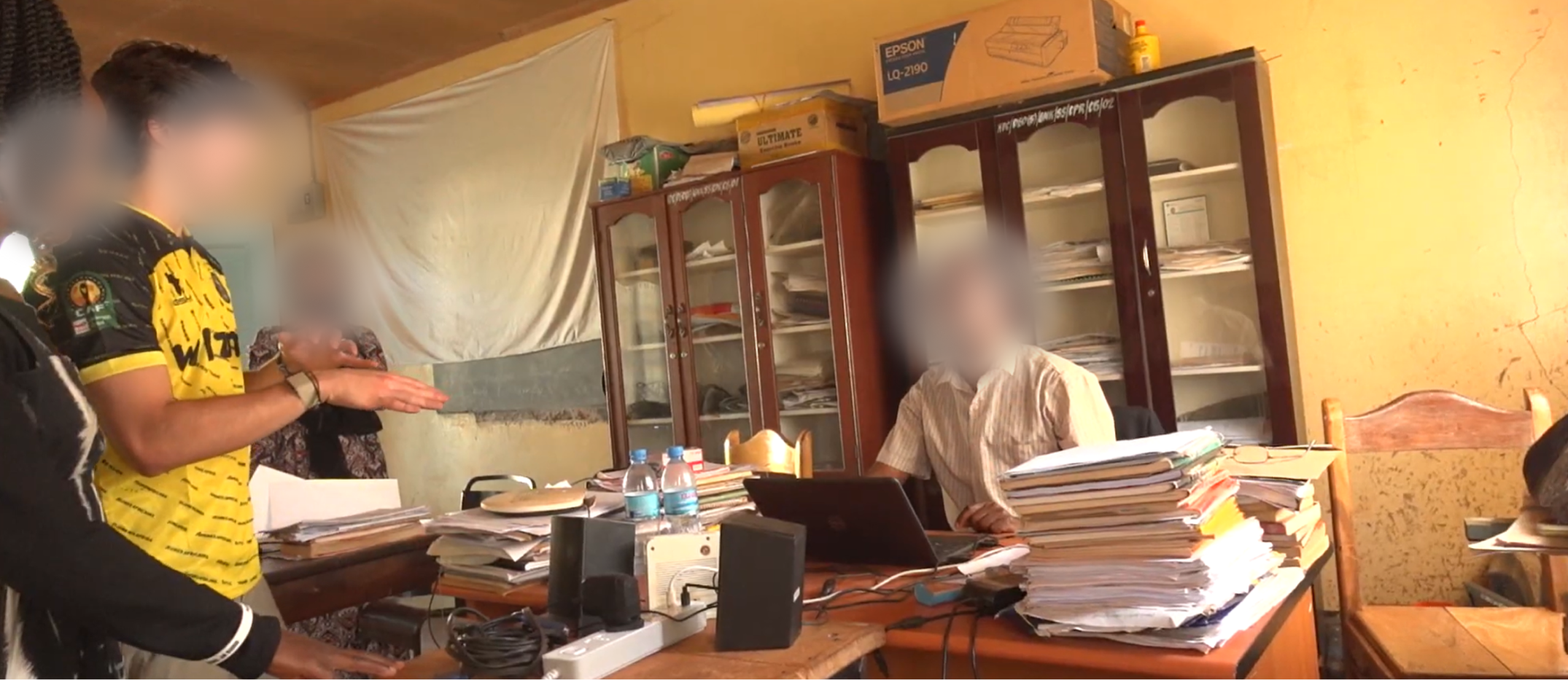 Nova field researchers speaking with an educator in a school office