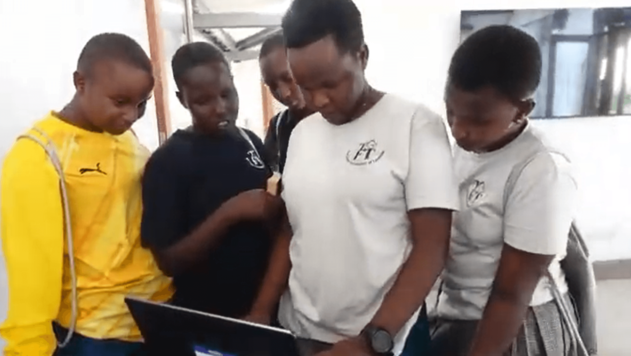 Students in South Sudan gathered around a laptop running Nova